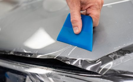 paint protection film being installed on a gray car.